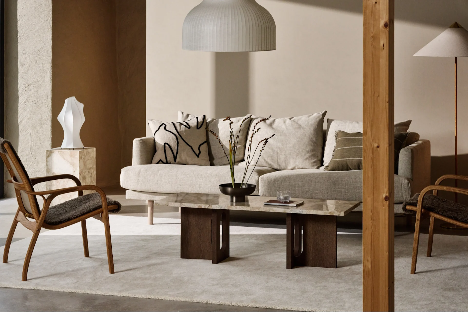 Moderne woonkamer met lichte bank, marmeren salontafel, houten fauteuils en neutrale inrichting.