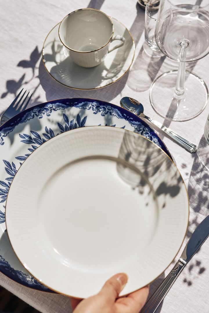 Een mooie feestelijke tafelschikking in blauw en wit met wit linnen en verse bloemen. Hier Ostindia Floris bord in blauw en wit samen met het witte bord uit de Zweedse Grace Gala serie van Rörstrand.