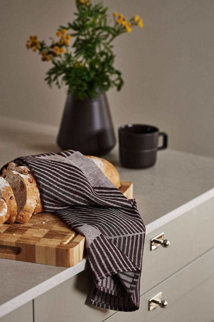 Cadeau-ideeën voor kerst: De veelzijdige en stijlvolle Stripes theedoek van NJRD in bruin en wit, hier afgebeeld gewikkeld rond een brood, is een geweldig cadeau voor kerst.