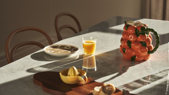 Hier zie je een gedekte tafel met Marimekko servies, sap en karaf van BYON in het ontwerp van mandarijnen. 