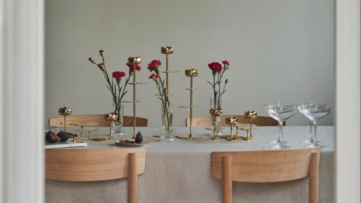 Deze eettafel is prachtig gedecoreerd met Hilke-kandelaars en rode bloemen, voor een stijlvolle en sfeervolle uitstraling.