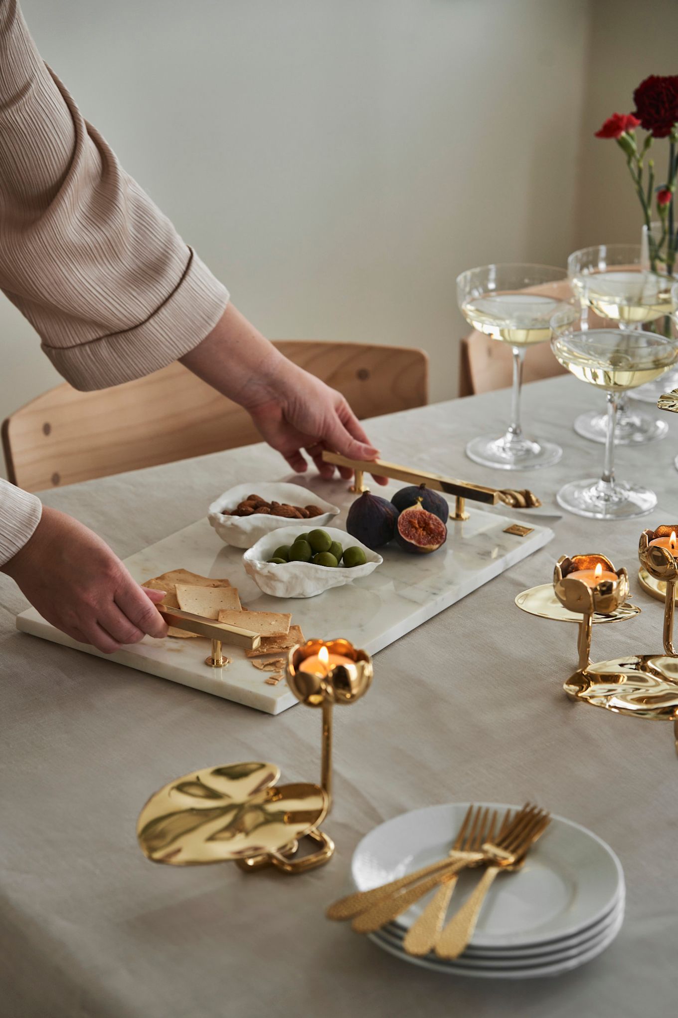 Nodig je vriendinnen uit voor een afternoon tea op Galentijnsdag. Hier zie je een marmeren dienblad van Hilke Collection en gouden kandelaars in de vorm van waterlelies.