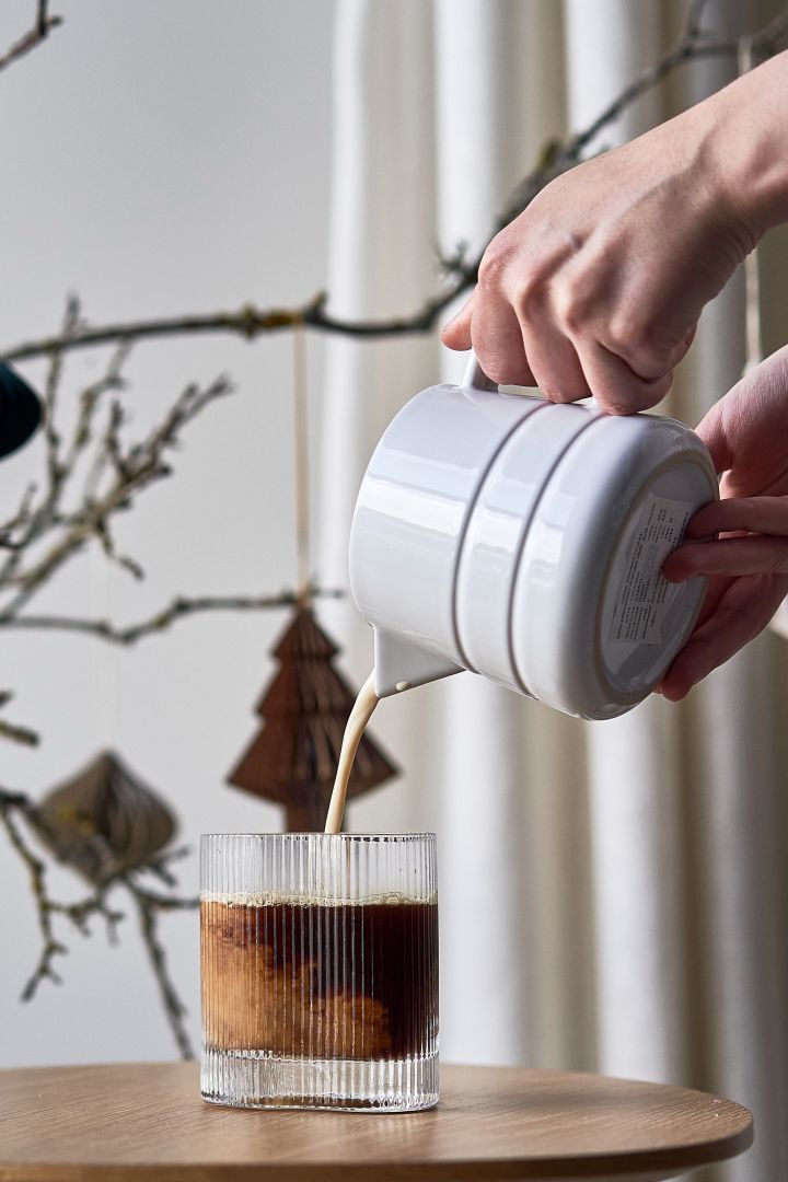 Eenvoudige kerstcocktails: Schenk de koffie in het Ripe-glas van Muubs en de warme melk in de Lines-kan van NJRD.