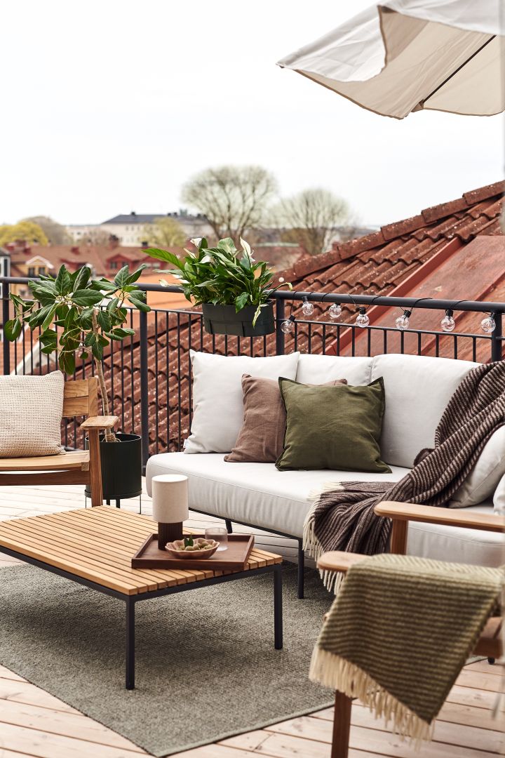 Draagbare verlichting van &Tradition, planten, zachte kussens en plaids van Scandi Living en NJRD zijn perfect om het balkon te versieren.