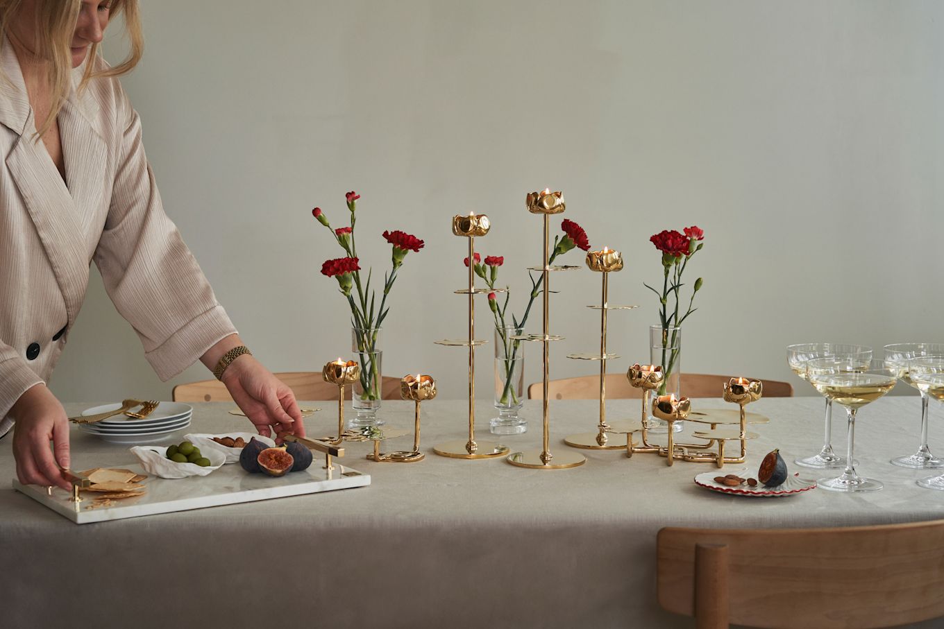 Elegant gedekte tafels zijn een trend die we in 2025 graag omarmen. Hier met messing kandelaars van Hilke, rode bloemen en een linnen tafelkleed, creëren we een verfijnde en uitnodigende sfeer die perfect past bij de esthetiek van dit jaar.