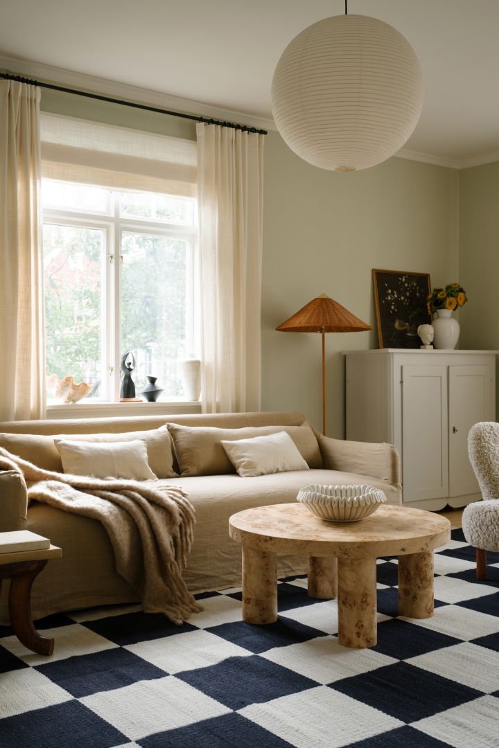 De juiste plafondlamp vinden voor je woonkamer: Hier zie je de eenvoudige Rice Paper lampenkap van HAY in een Scandinavisch-moderne woonkamer in beige.