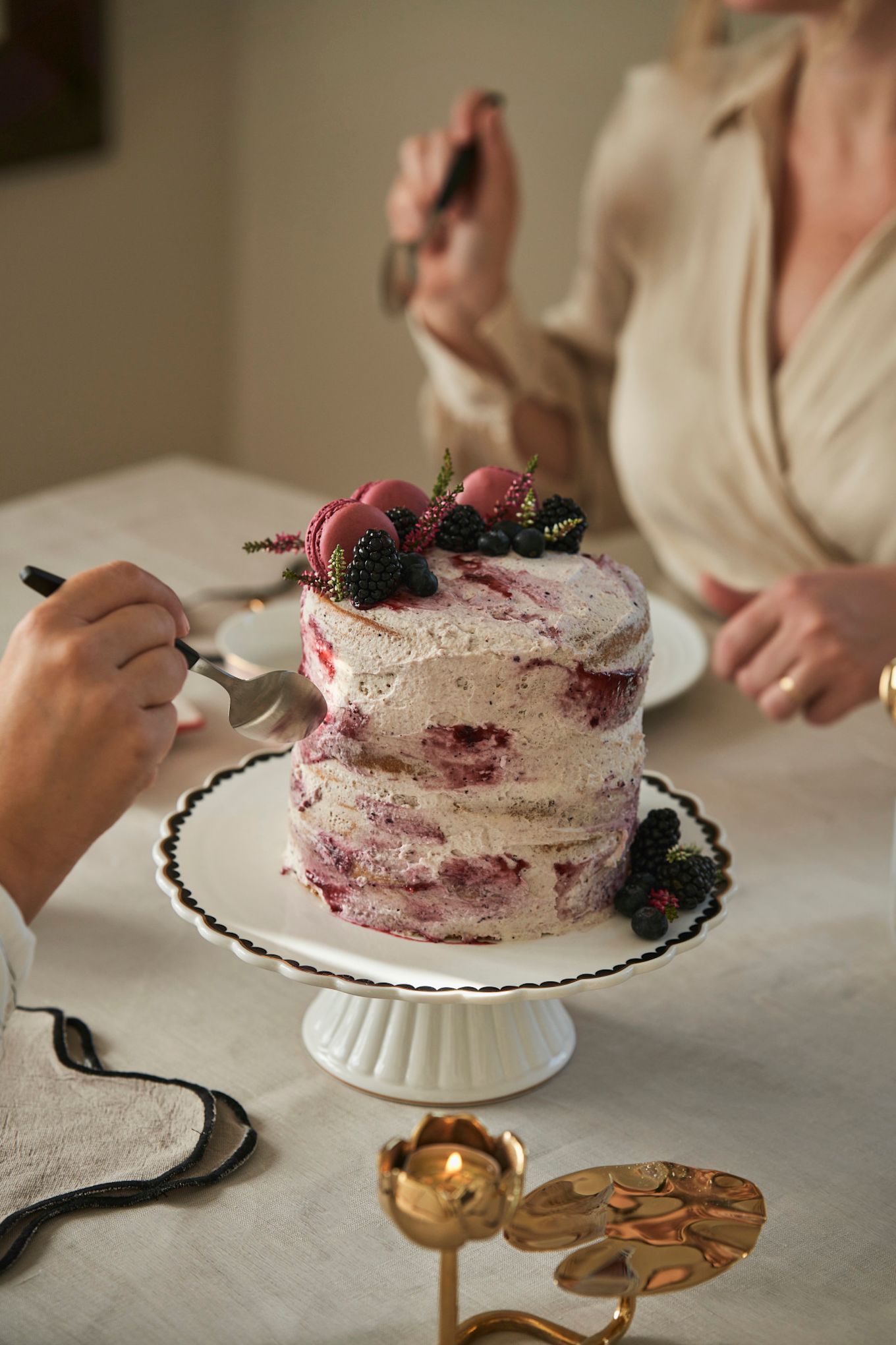 Vier Galentine's Day met een high tea. Hier zie je een speciale Galentine's Day taart met seizoensbessen en macarons. 