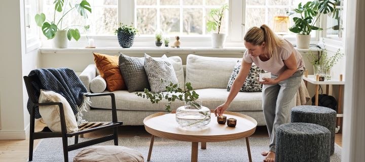 Creëer een gezellige hygge woonkamer met kaarsen, neutrale kleuren en natuurlijke materialen. 