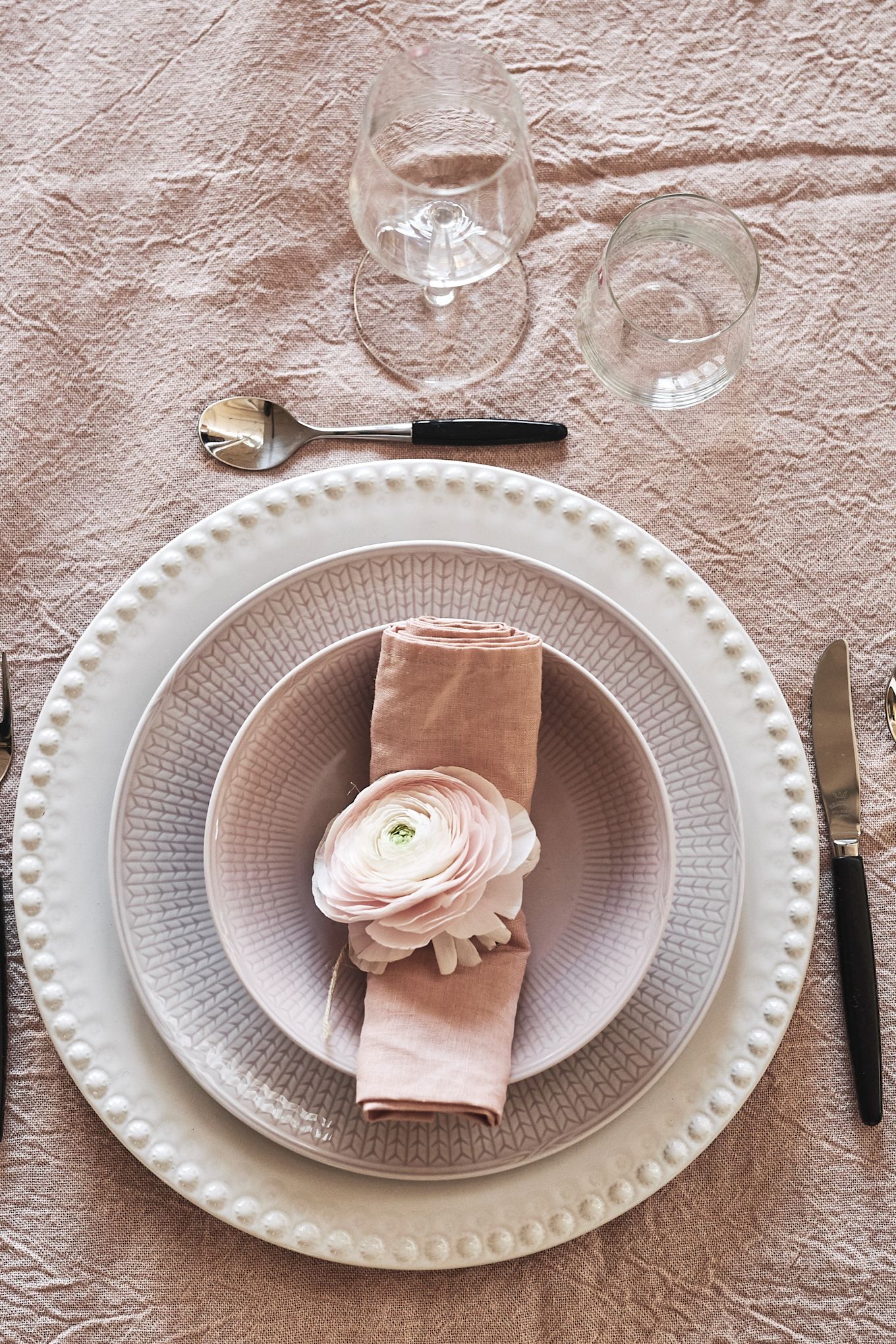 Roze servies is perfect voor een romantische diner thuis, bijvoorbeeld het roze servies uit de Zweedse Grace-collectie van Rörstrand, hier versierd met een bloem.