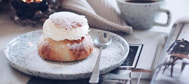 Populair Zweeds gebak is onder andere semlor - gistrolletjes gevuld met marsepein en room, die je hier kunt zien op een Poppi-bord van Olsson & Jensen in het huis van de Zweedse influencer @picsbyellen.