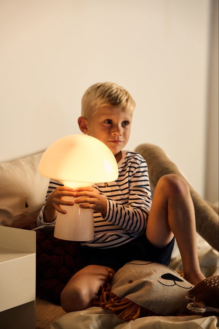 Kies de juiste lamp - een jongetje houdt een lichtgevende lamp in de vorm van een paddenstoel vast.