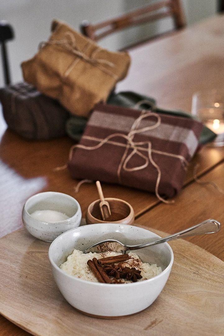 Een kerstrijstpudding wordt op tafel geserveerd in een rustieke schaal.