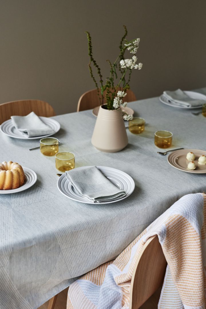 Creëer prachtige tafelschikkingen met stijlvol Scandi Living bestek, elegant Lines porselein van NJRD in wit samen met Geometric linnen servetten en linnen tafelkleed van NJRD in lichtblauw.