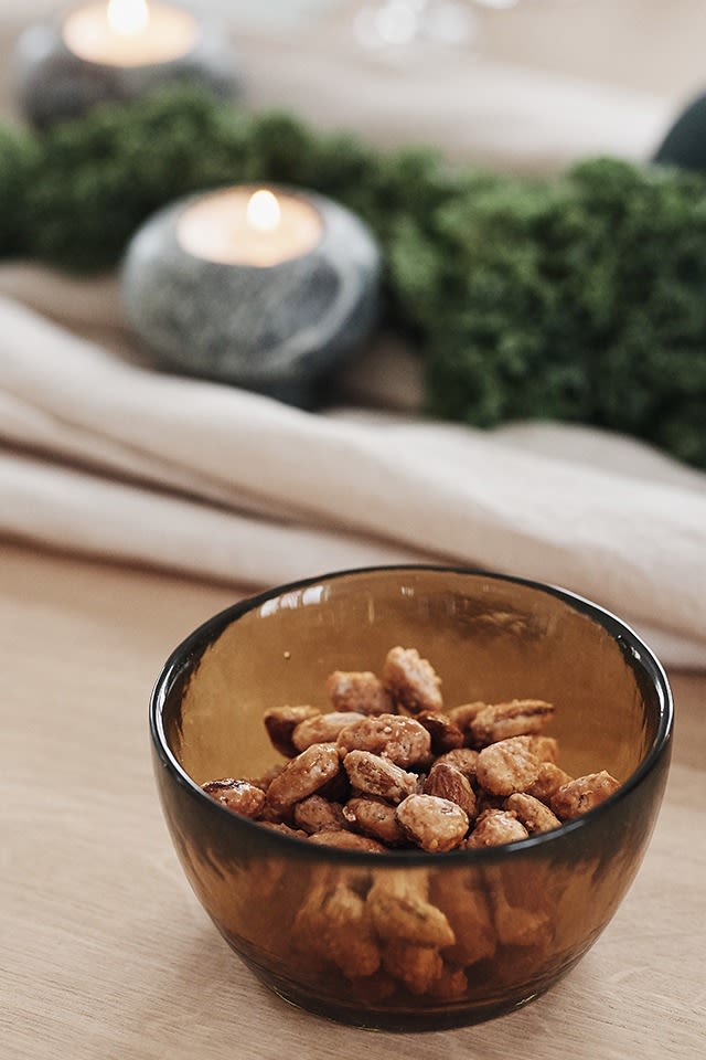 Scandinavische glühwein en andere lekkernijen: Hier zie je gekonfijte amandelen in een glazen schaaltje van Bitz op een feestelijke tafel.