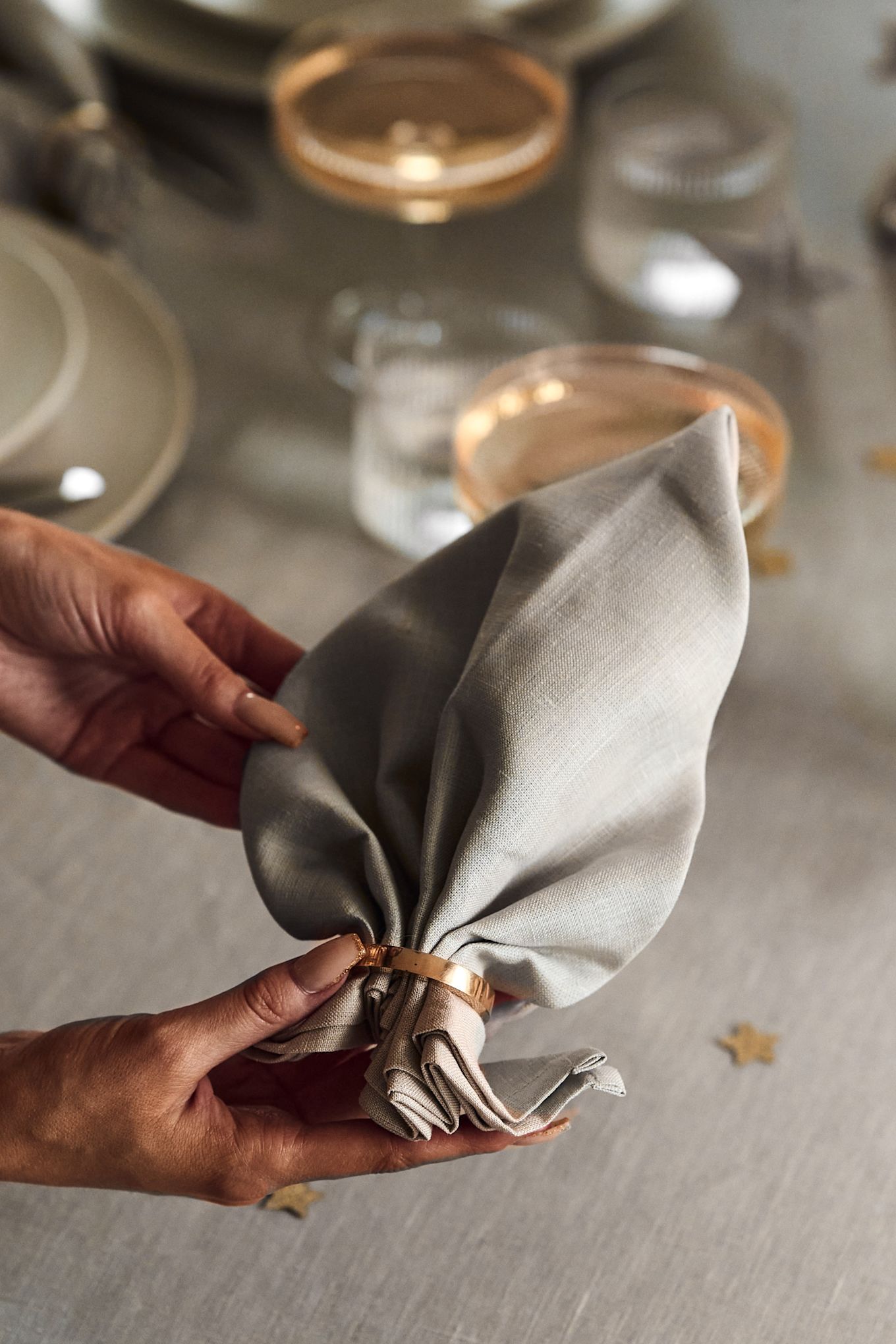 Ideeën voor je nieuwjaarsfeest: geef je tafel een elegant tintje door je eigen stoffen servetten te vouwen, zoals deze van Scandi Living, of door een servetring te gebruiken.