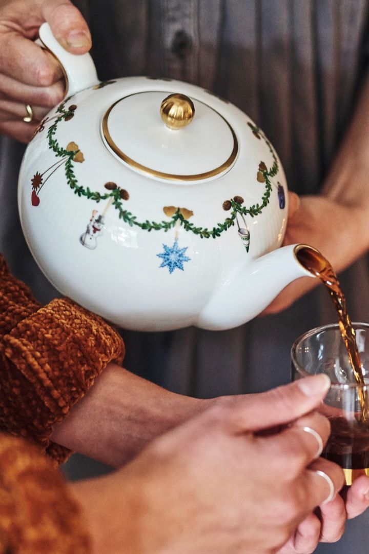 Scandinavische glühwein en andere kerstrecepten: Hier wordt Glögg op een sfeervolle manier gepresenteerd, geschonken uit de elegante Star Fluted Christmas theepot van Royal Copenhagen in een mooi glas. Het perfecte servies om je feestelijke drankjes en hapjes te serveren tijdens de kerstperiode.