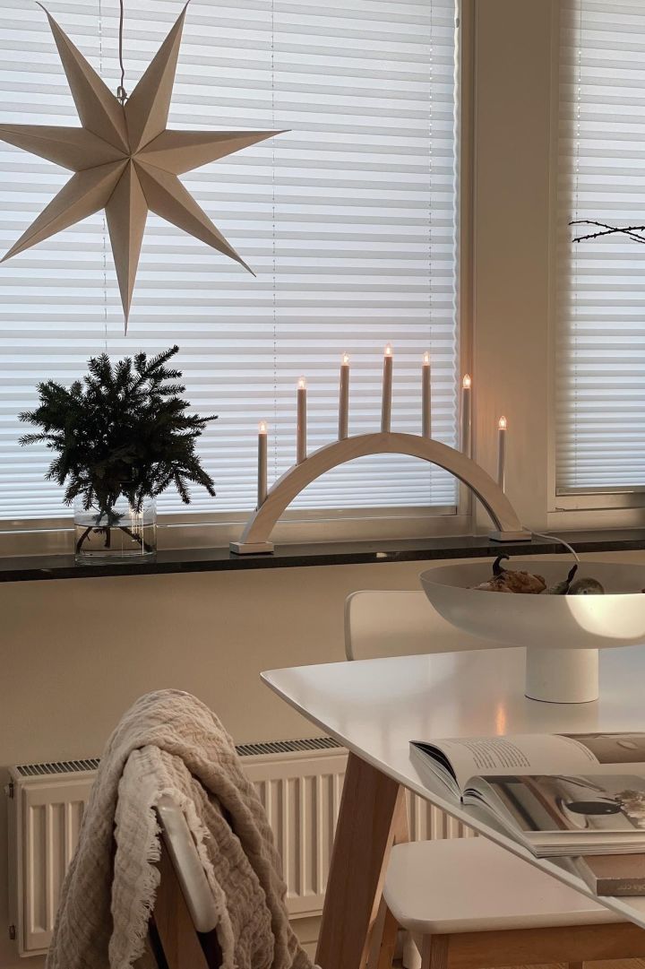 Hier zie je een eenvoudige Scandinavische vensterbankdecoratie voor Kerstmis. @myyjapandihomee heeft een Bare adventsster van Scandi Living voor het raam gehangen en de vensterbank versierd met dennengroen en de Sky adventskaarsenhouder van Scandi Living.