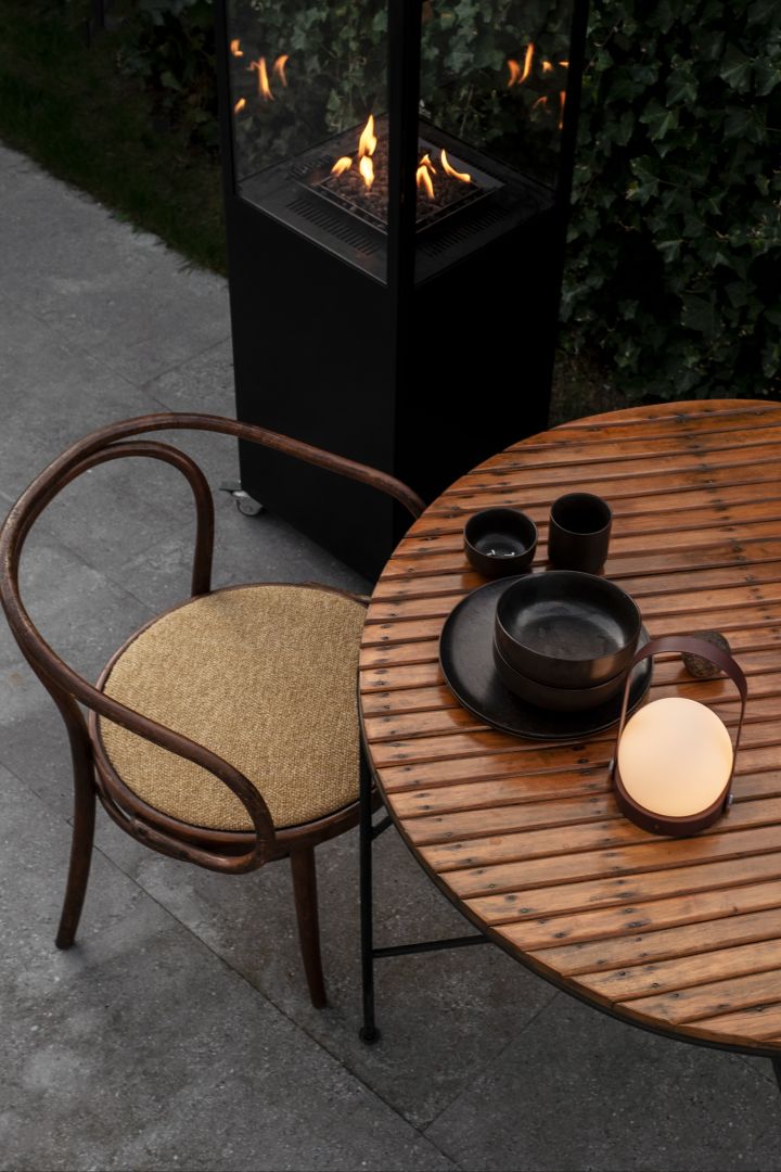 De Carrie lamp van Audo Copenhagen is een draagbare, draagbare lamp die lijkt op een lantaarn. Carrie is perfect om mee te nemen naar de tuin of patio waar hij de eethoek of loungehoek kan verlichten.