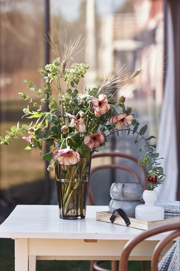 Geniet van een kopje koffie en adem de geur in van verse bloemen van Blombruket, geplaatst in een vaas van Iittala.